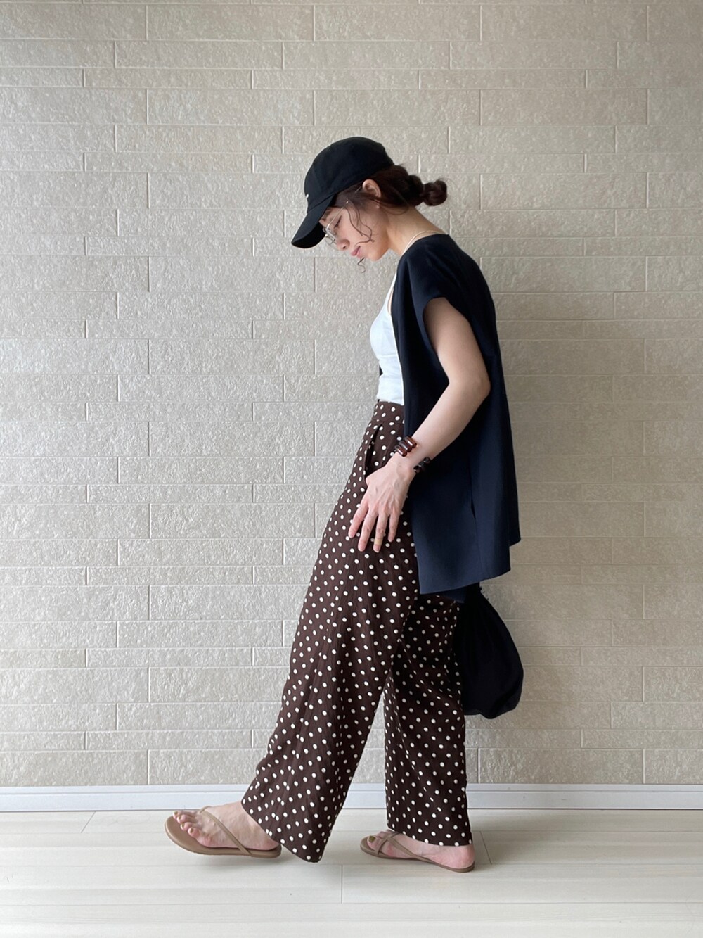 ブラウン系のその他パンツ、ブラック系のベスト、ブラウン系のサンダルを着用したレディースの夏コーディネートの3枚目の写真