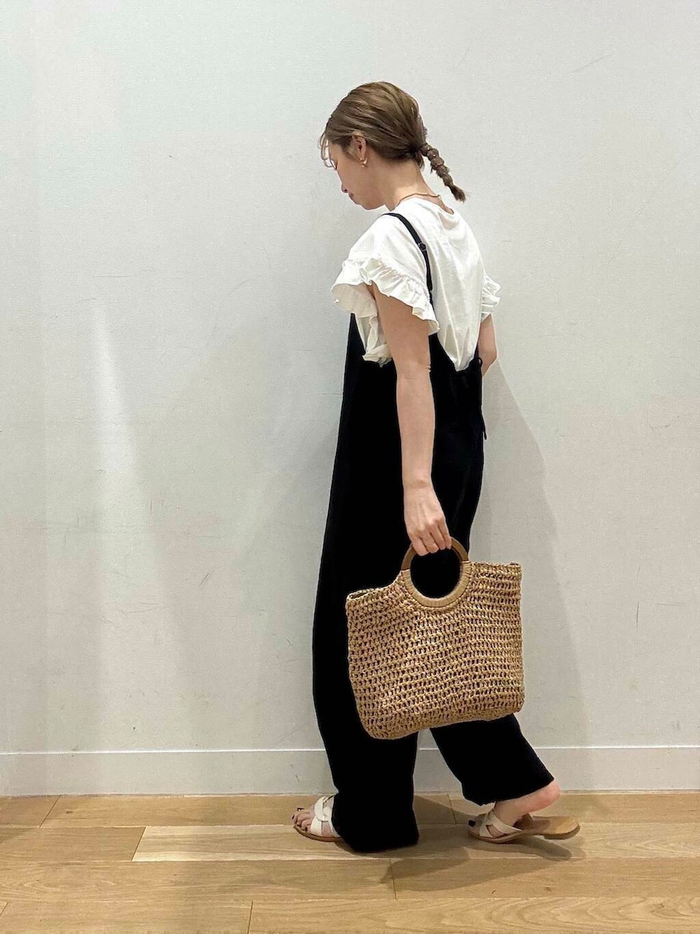 ホワイト系のサンダル、ベージュ系のトートバッグ、ブラック系のサロペット/オーバーオールを着用したレディースの春コーディネートの4枚目の写真