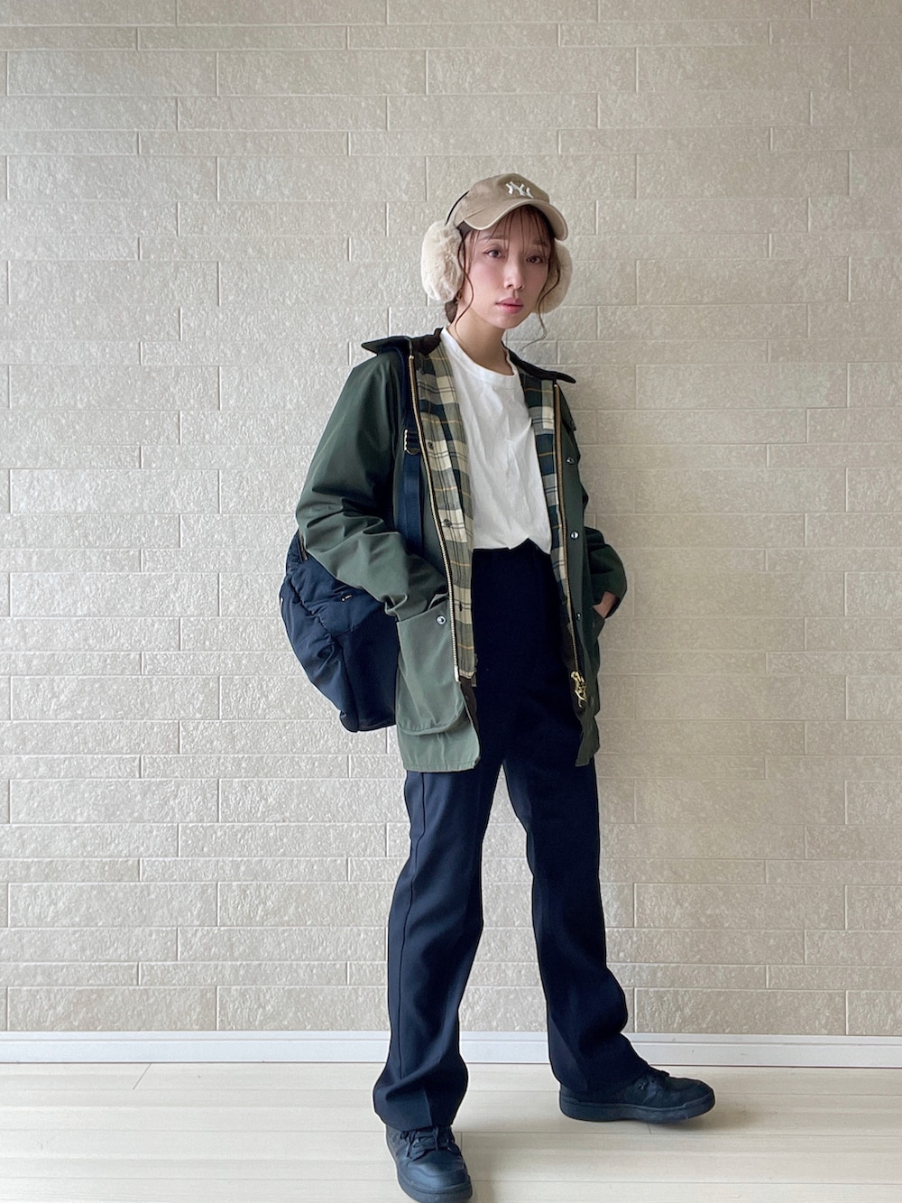 ブラック系のスラックス、グリーン系のブルゾン、ブラック系のスニーカーを着用したレディースの秋コーディネートの5枚目の写真