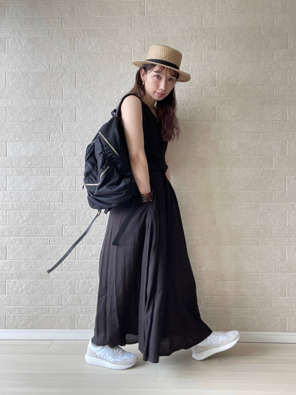 ブラック系のワンピース、ベージュ系のスニーカー、ブラック系のバックパック/リュックを着用したレディースの夏コーディネートの3枚目の写真