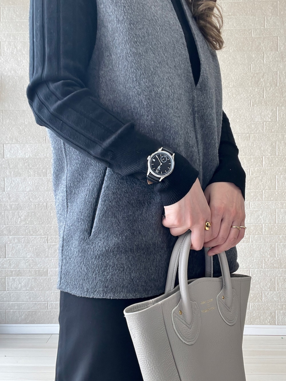 ベージュ系のトートバッグ、ブラック系のその他パンツ、グレー系のベストを着用したレディースの冬コーディネートの3枚目の写真