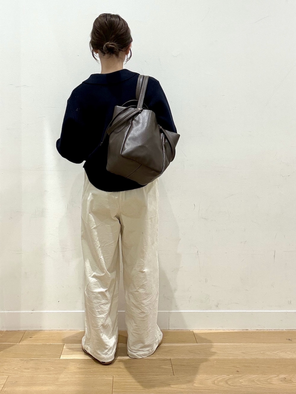 ブルー系のニット/セーター、ブラウン系のトートバッグ、ホワイト系のその他パンツを着用したレディースの冬コーディネートの2枚目の写真