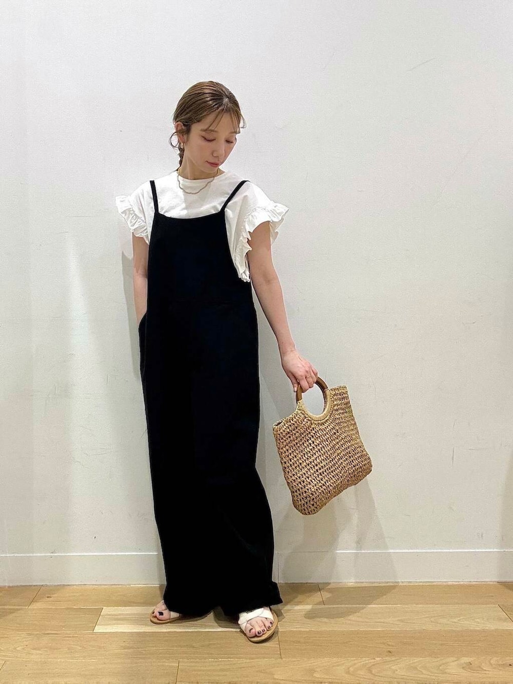 ホワイト系のサンダル、ベージュ系のトートバッグ、ブラック系のサロペット/オーバーオールを着用したレディースの春コーディネートの5枚目の写真