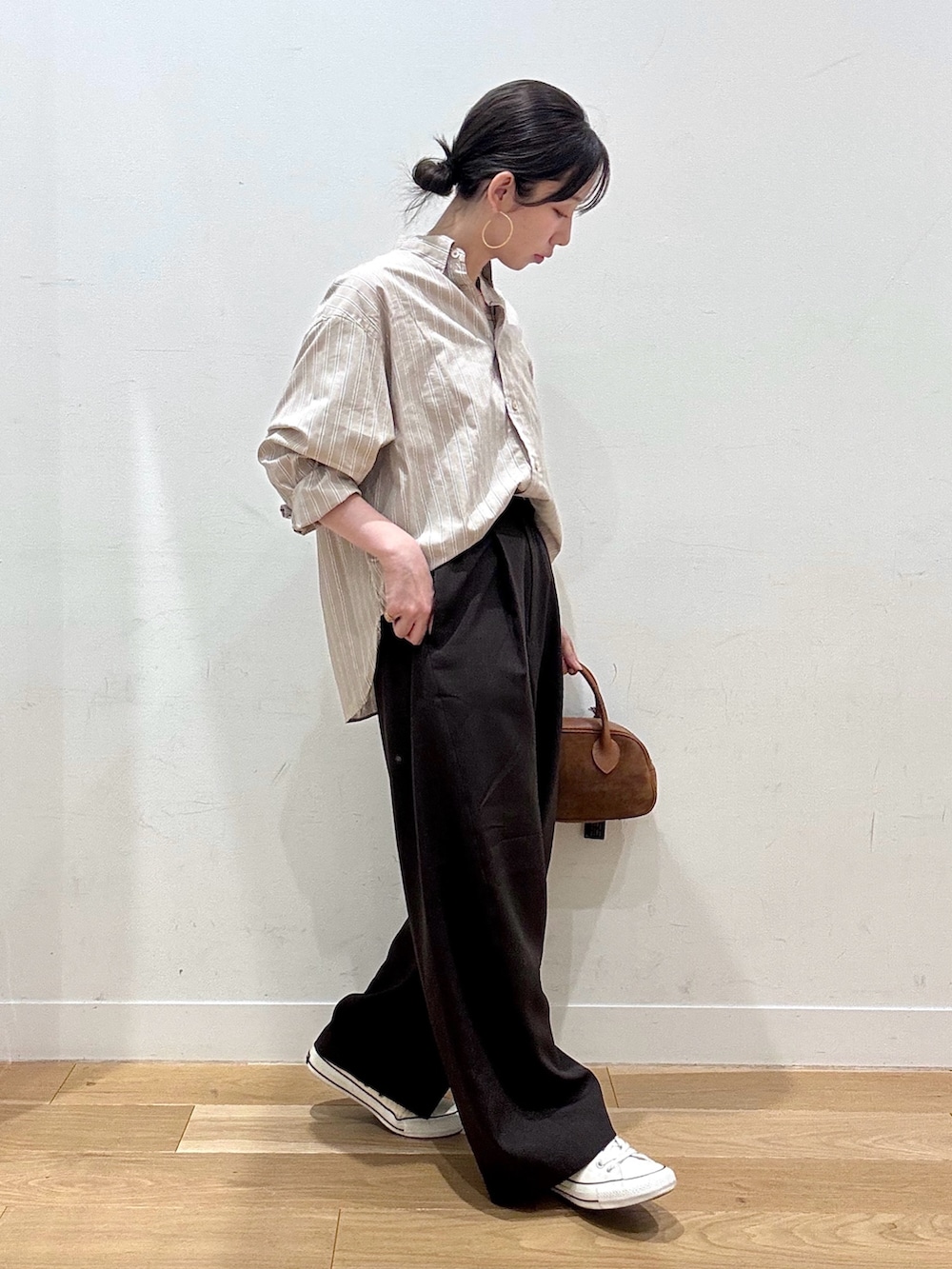 ホワイト系のスニーカー、ベージュ系のシャツ/ブラウス、ブラウン系のショルダーバッグを着用したレディースの秋コーディネートの2枚目の写真