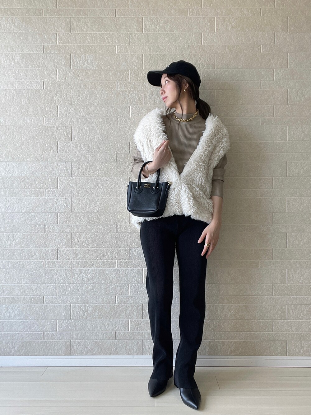 ブラック系のブーツ、ベージュ系のニット/セーター、ブラック系のその他パンツを着用したレディースの秋コーディネートの2枚目の写真