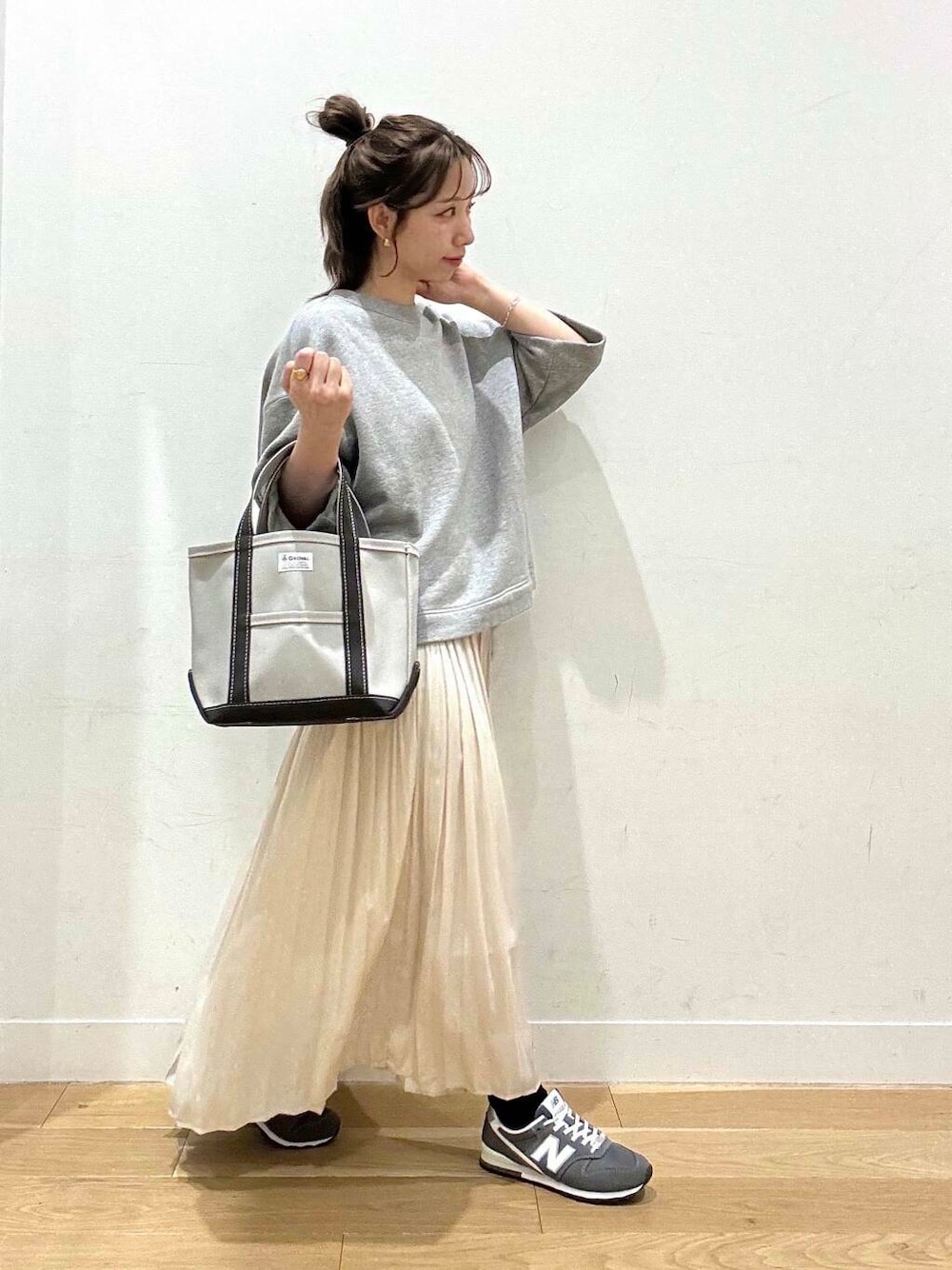 ブラック系のマウンテンパーカー、ホワイト系のスカート、グレー系のスウェットを着用したレディースの春コーディネートの5枚目の写真