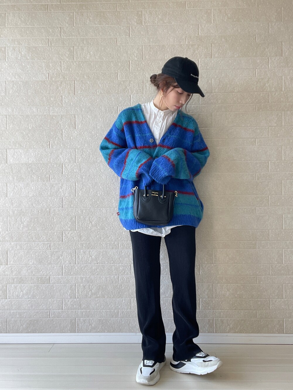 ブラック系のその他パンツ、ブラック系のトートバッグ、ホワイト系のスニーカーを着用したレディースの秋コーディネートの3枚目の写真