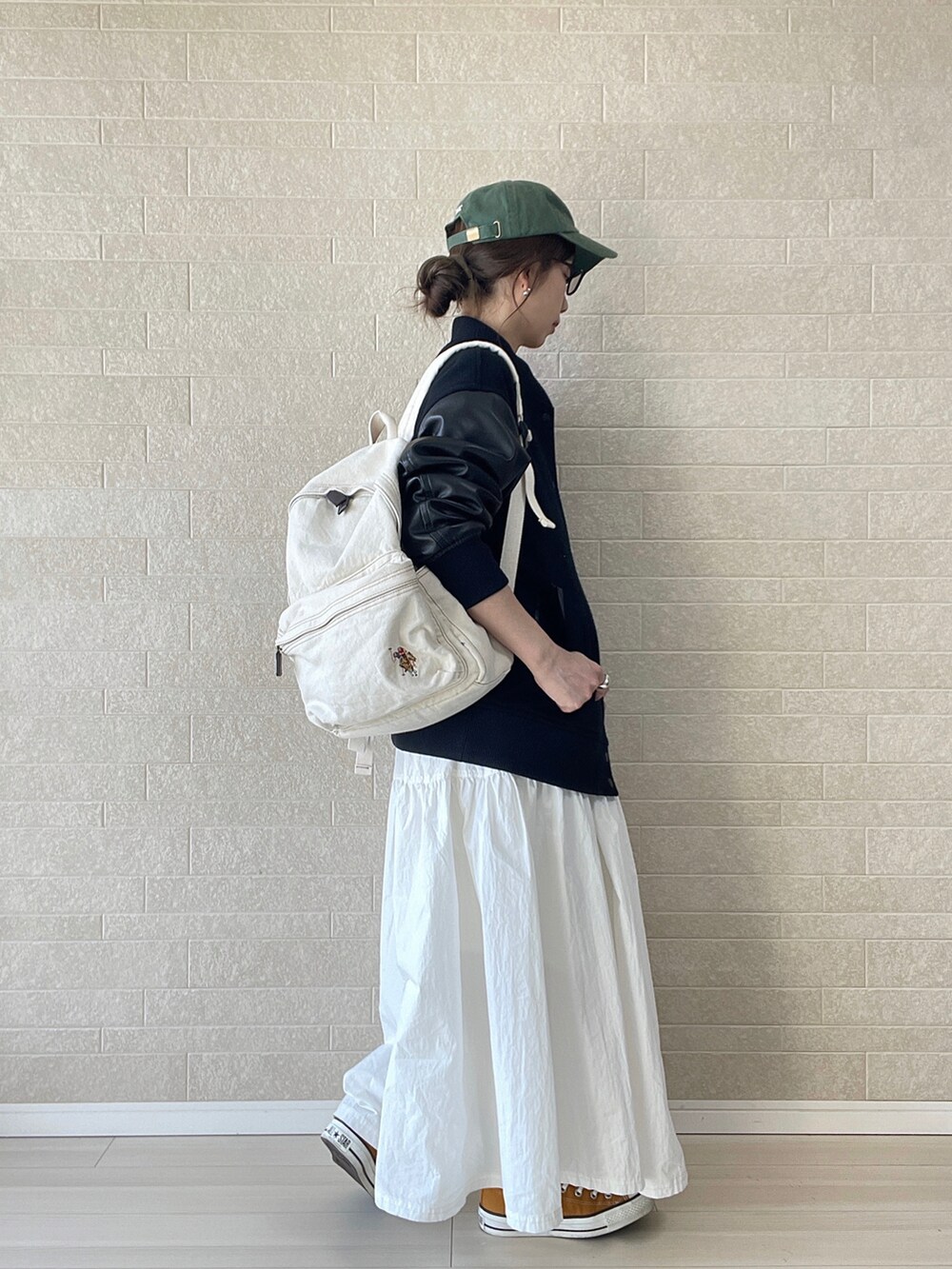 ホワイト系のバックパック/リュック、ブラック系のスタジャン、ホワイト系のワンピースを着用したレディースの冬コーディネートの3枚目の写真