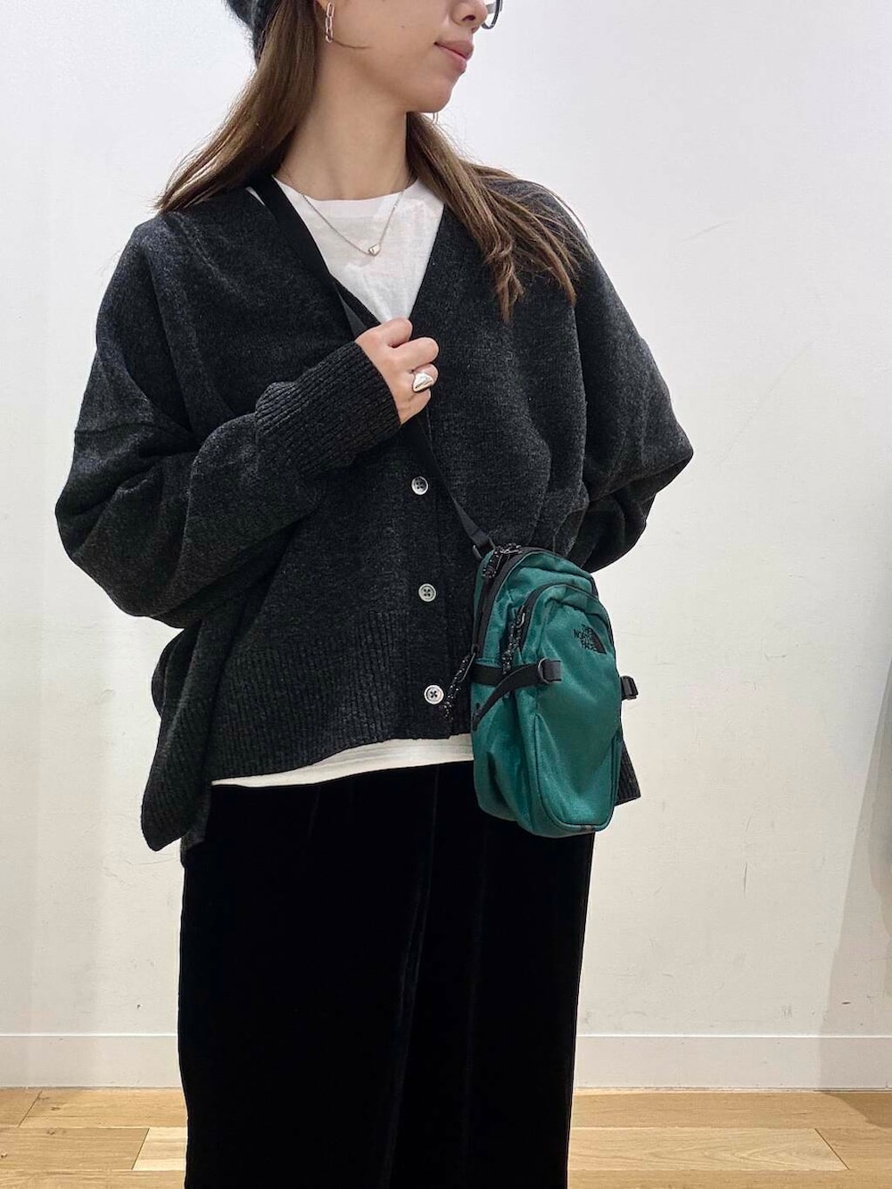 ブラック系のその他パンツ、ホワイト系のTシャツ/カットソー、グレー系のニット/セーターを着用したレディースの冬コーディネートの7枚目の写真