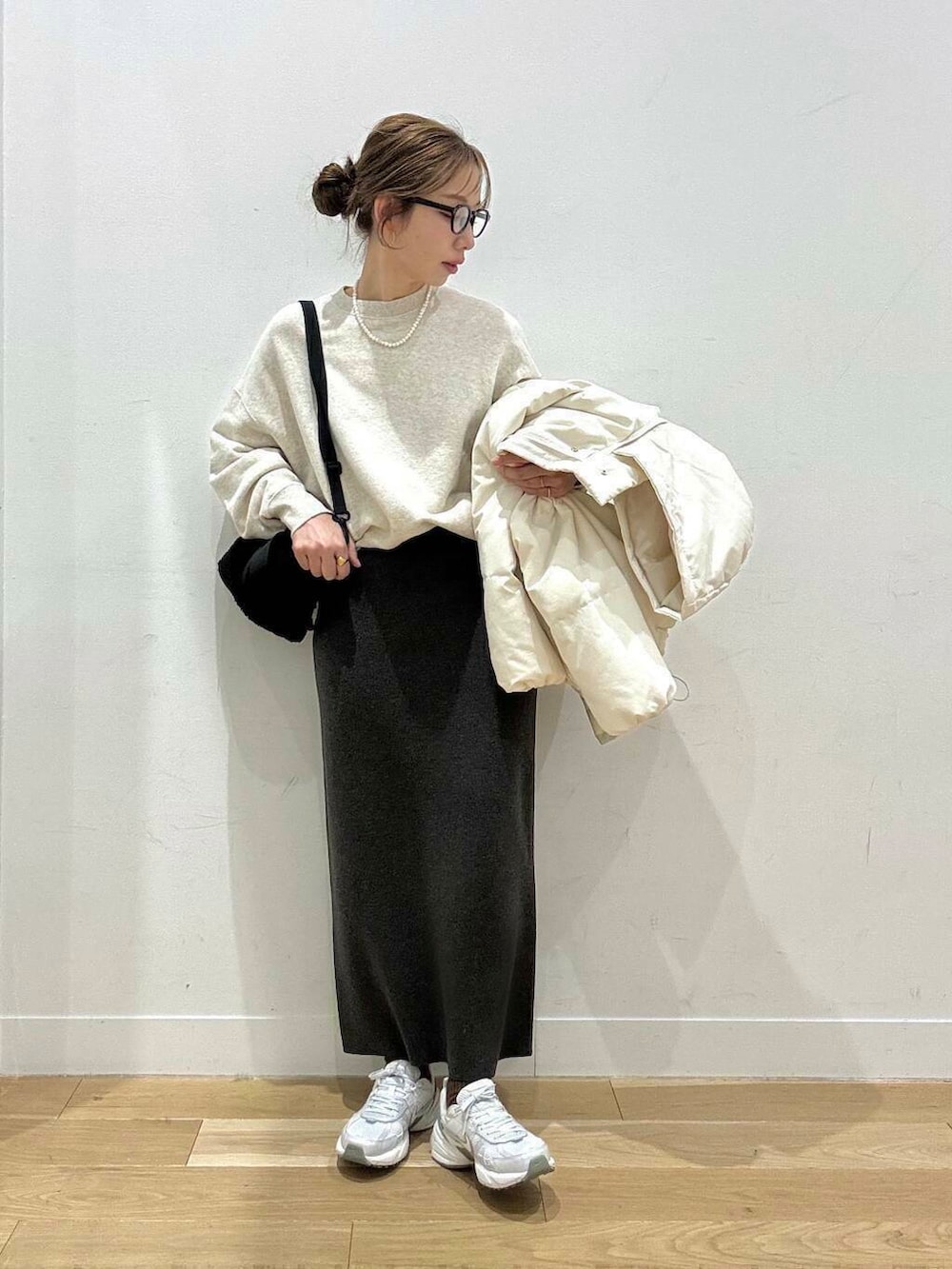 ホワイト系のスニーカー、グレー系のスカート、ホワイト系のダウンジャケット/コートを着用したレディースの冬コーディネートの5枚目の写真