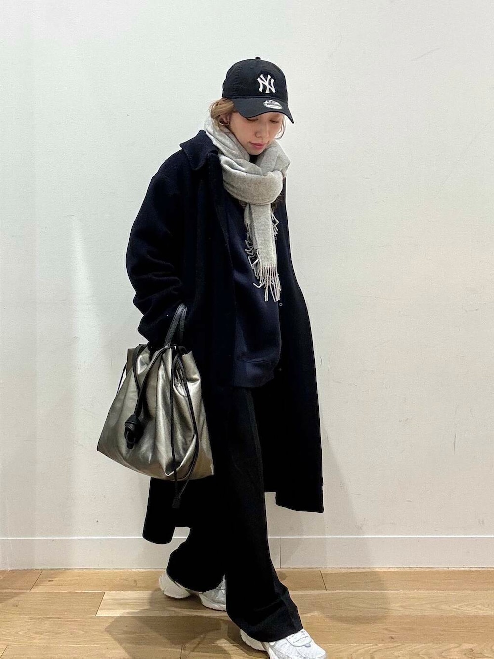 シルバー系のトートバッグ、シルバー系のスニーカー、ブルー系のスウェットを着用したレディースの冬コーディネートの5枚目の写真