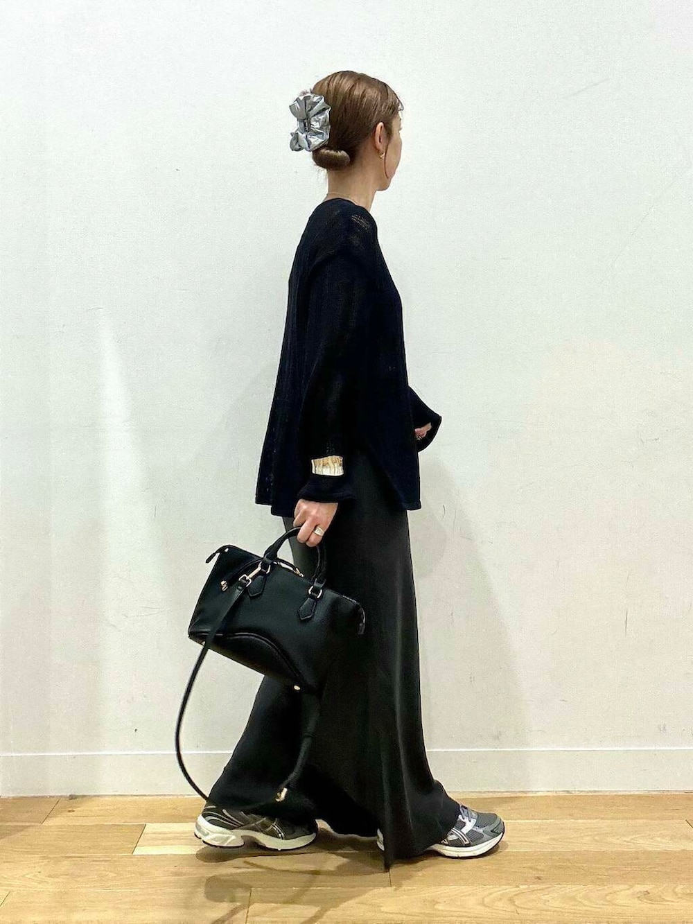 ブラウン系のタンクトップ、グレー系のスカート、ブラック系のボストンバッグを着用したレディースの秋コーディネートの5枚目の写真