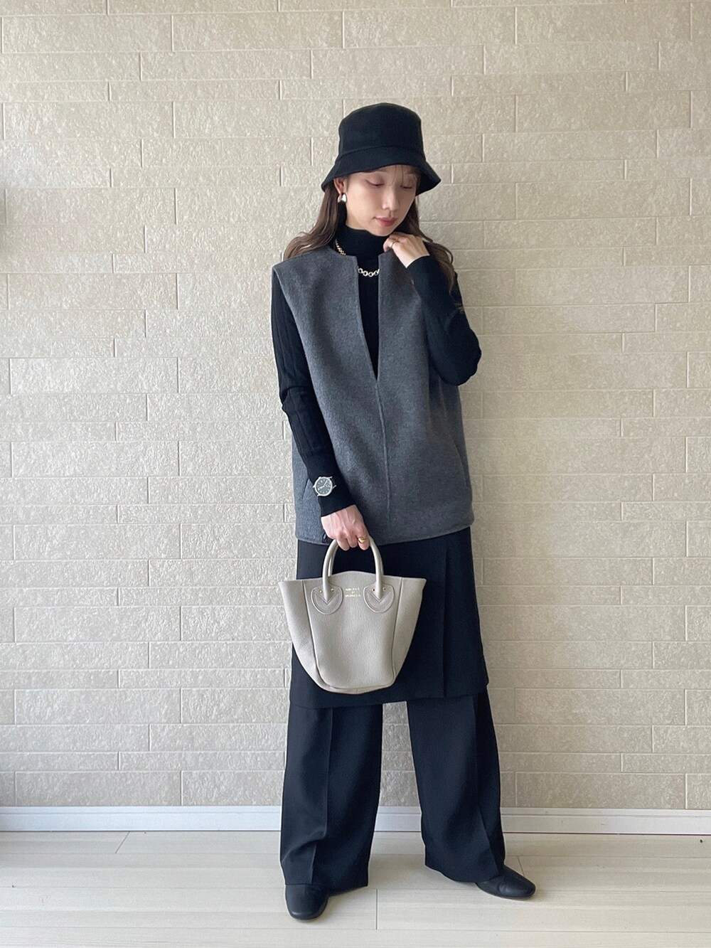 ベージュ系のトートバッグ、ブラック系のその他パンツ、グレー系のベストを着用したレディースの冬コーディネートの2枚目の写真