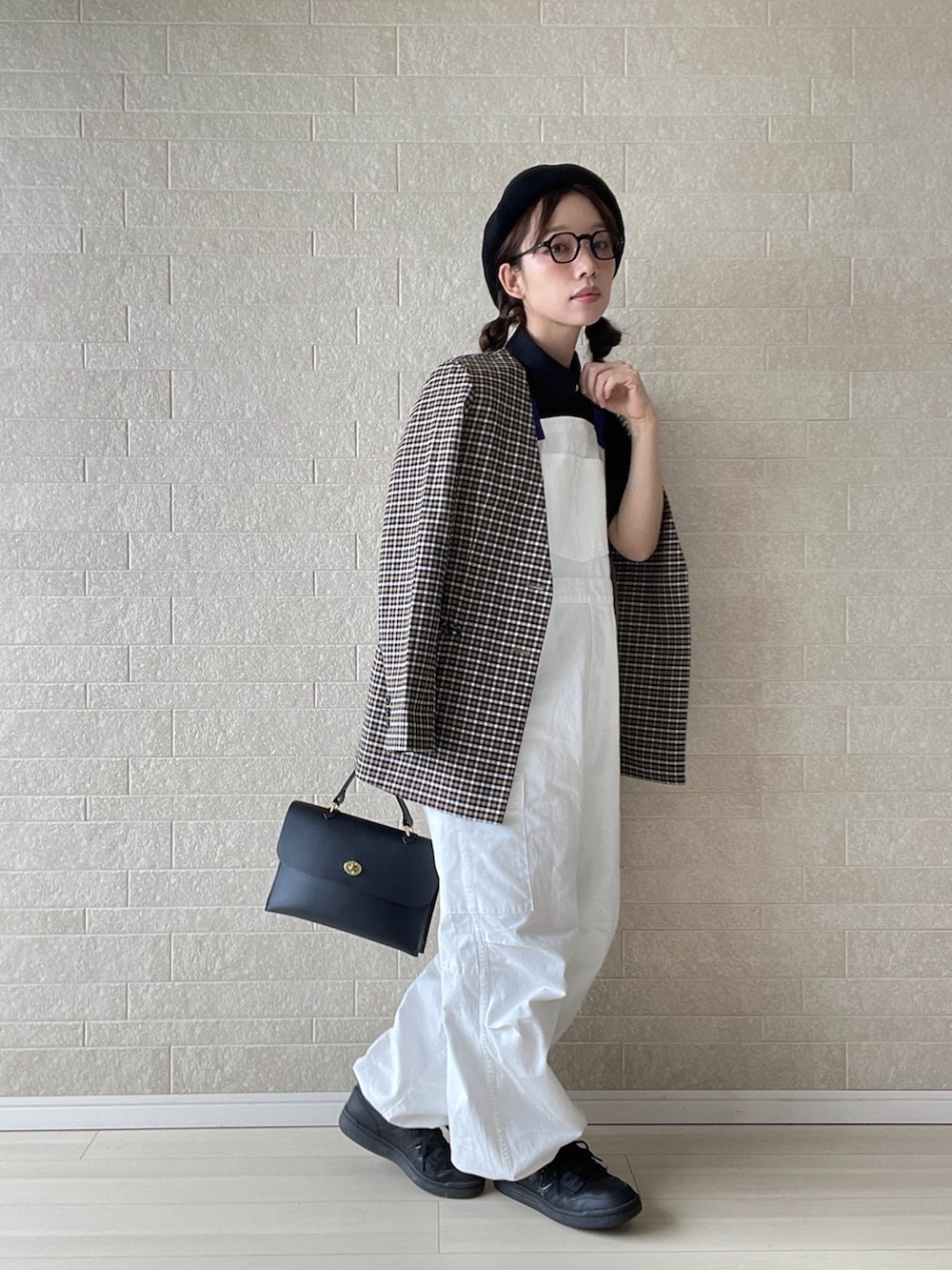 ホワイト系のサロペット/オーバーオール、ブラック系のポロシャツ、ブラック系のショルダーバッグを着用したレディースの秋コーディネートの5枚目の写真