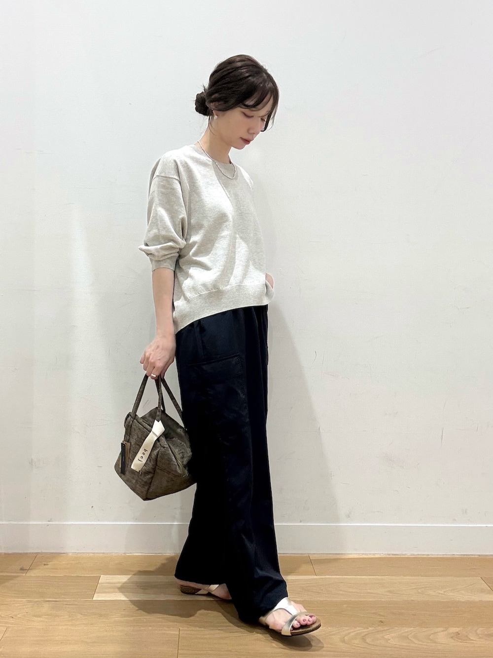 グリーン系のハンドバッグ、ベージュ系のその他トップス、ブルー系のその他パンツを着用したレディースの秋コーディネートの3枚目の写真