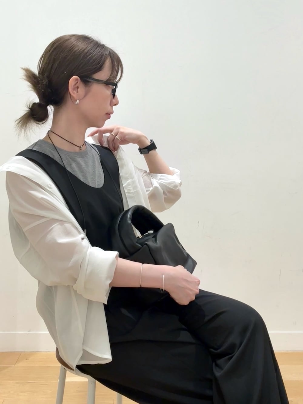 ブラック系のハンドバッグ、ブラック系のワンピース、グレー系のTシャツ/カットソーを着用したレディースの秋コーディネートの5枚目の写真