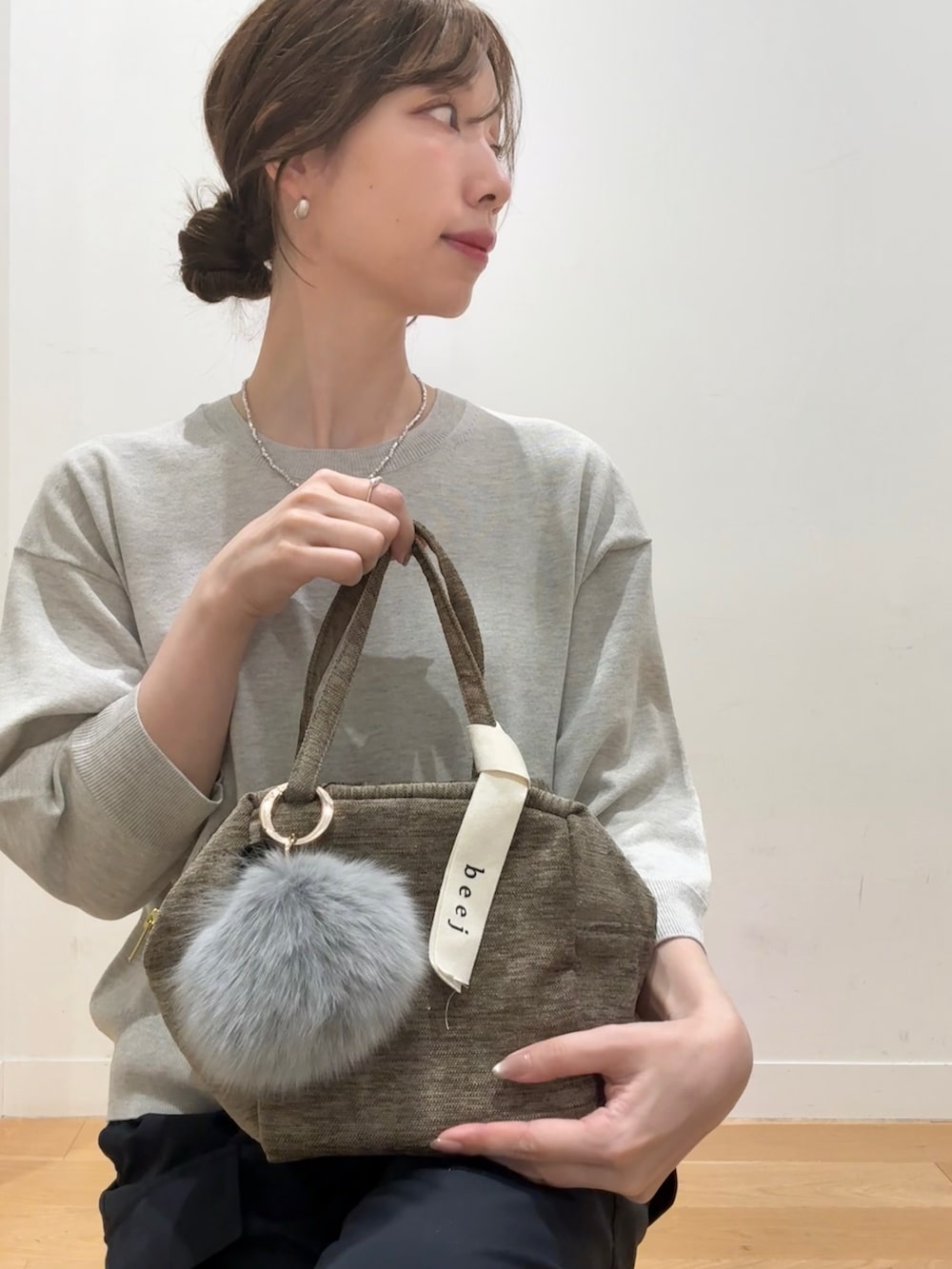 グリーン系のハンドバッグ、ベージュ系のその他トップス、ブルー系のその他パンツを着用したレディースの秋コーディネートの5枚目の写真