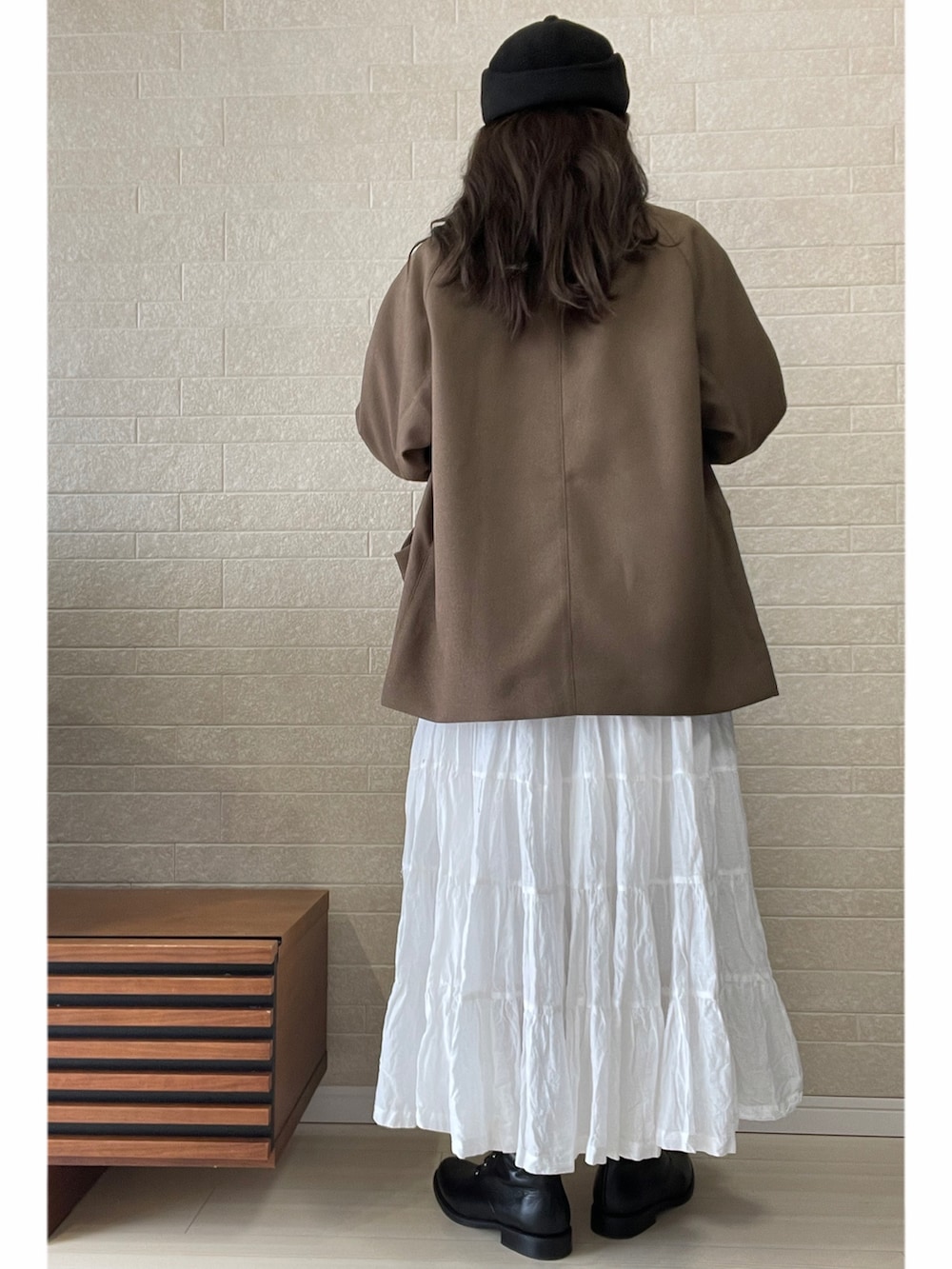 ベージュ系のブルゾン、ブラック系のスウェット、ブラック系のブーツを着用したレディースの冬コーディネートの3枚目の写真