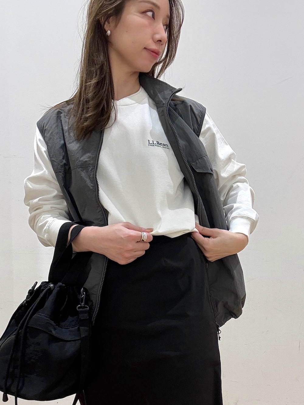 ブラック系のショルダーバッグ、ブラック系のスカート、グレー系のナイロンジャケットを着用したレディースの冬コーディネートの5枚目の写真