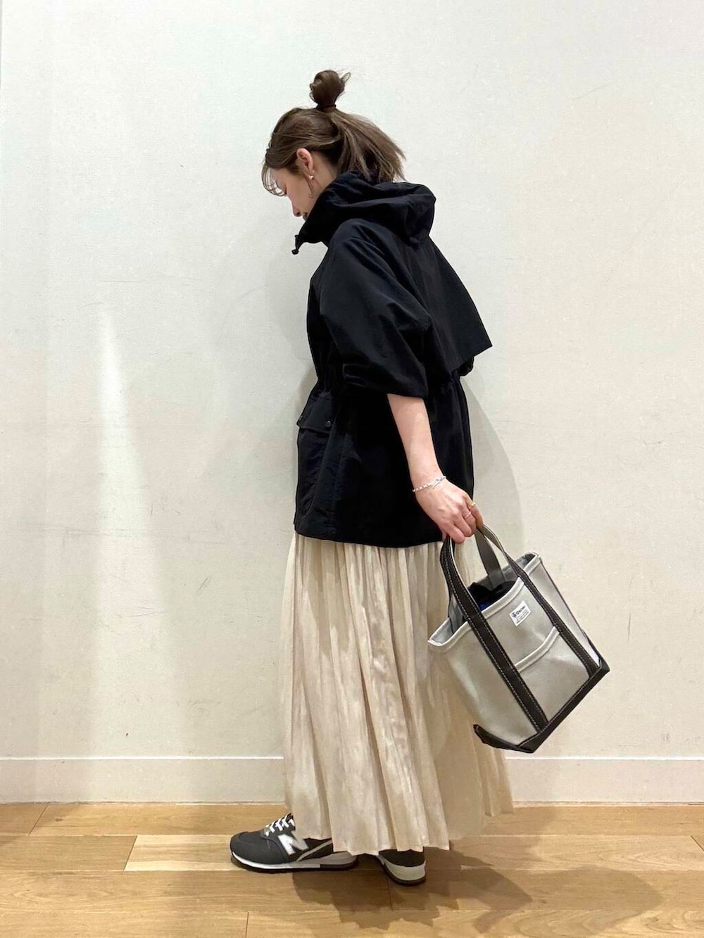 ブラック系のマウンテンパーカー、ホワイト系のスカート、グレー系のスウェットを着用したレディースの春コーディネートの3枚目の写真