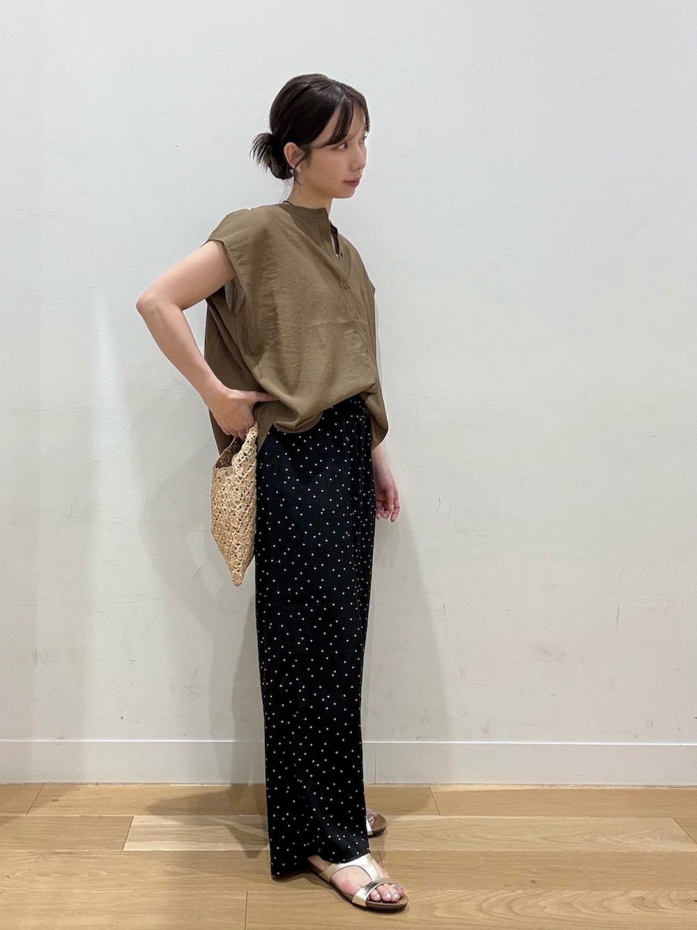 ベージュ系のハンドバッグ、ベージュ系のシャツ/ブラウス、ブラック系のその他パンツを着用したレディースの夏コーディネートの2枚目の写真