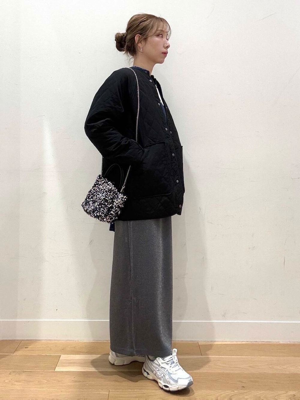 シルバー系のショルダーバッグ、グレー系のスカート、グレー系のTシャツ/カットソーを着用したレディースの冬コーディネートの6枚目の写真