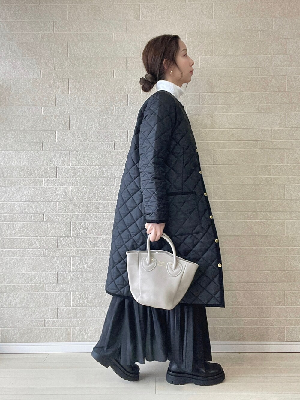 ブラック系のその他アウター、ブラウン系のベスト、ブラック系のブーツを着用したレディースの冬コーディネートの3枚目の写真