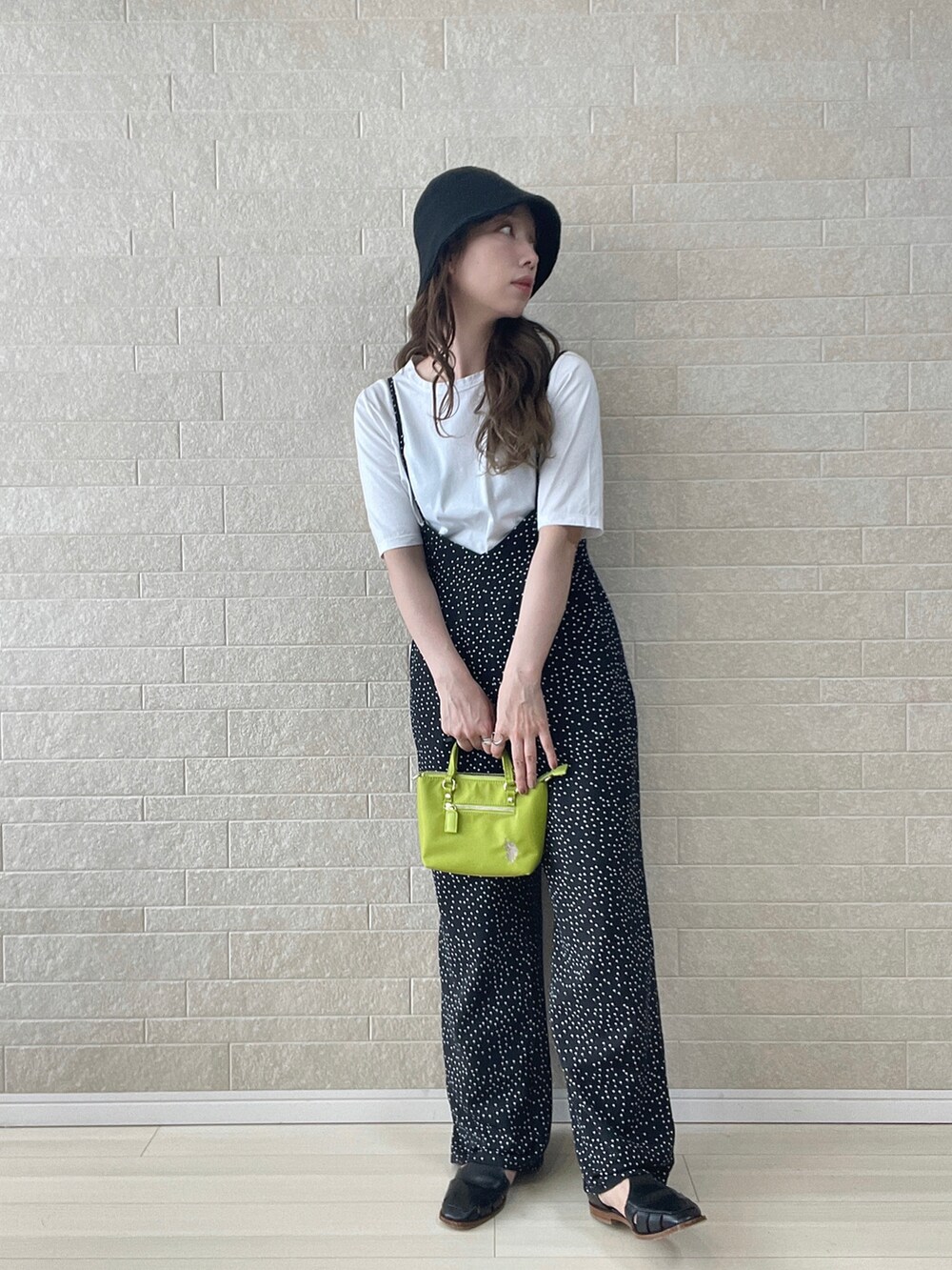 グリーン系のショルダーバッグ、ブラック系のサロペット/オーバーオール、ブラック系のサンダルを着用したレディースの夏コーディネートの2枚目の写真