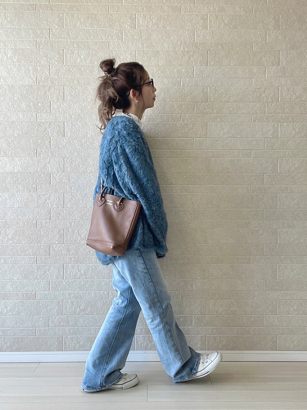 ブルー系のデニムパンツ、ホワイト系のシャツ/ブラウス、ブルー系のニット/セーターを着用したレディースの秋コーディネートの2枚目の写真