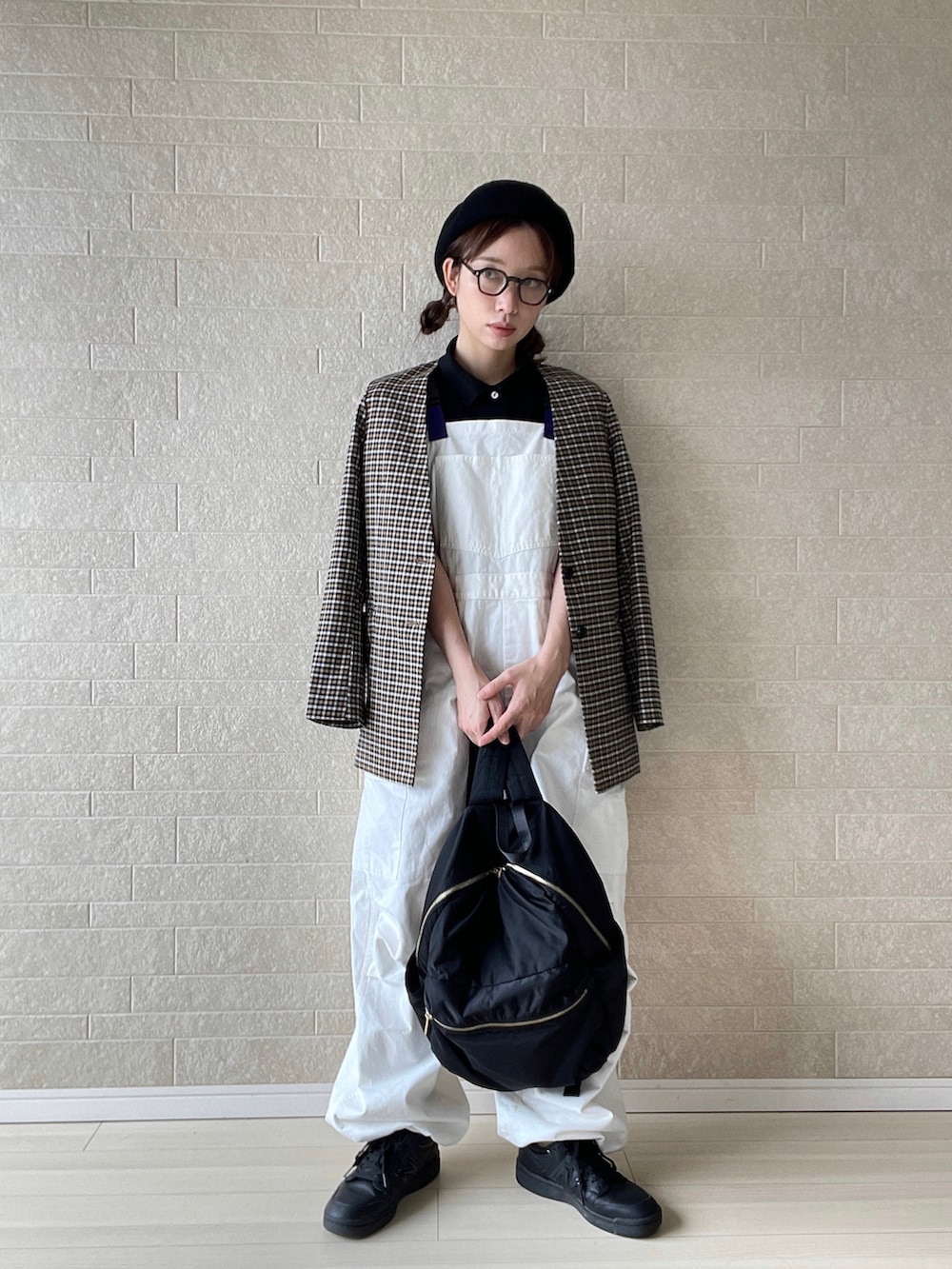 ホワイト系のサロペット/オーバーオール、ブラック系のポロシャツ、ブラック系のショルダーバッグを着用したレディースの秋コーディネートの2枚目の写真
