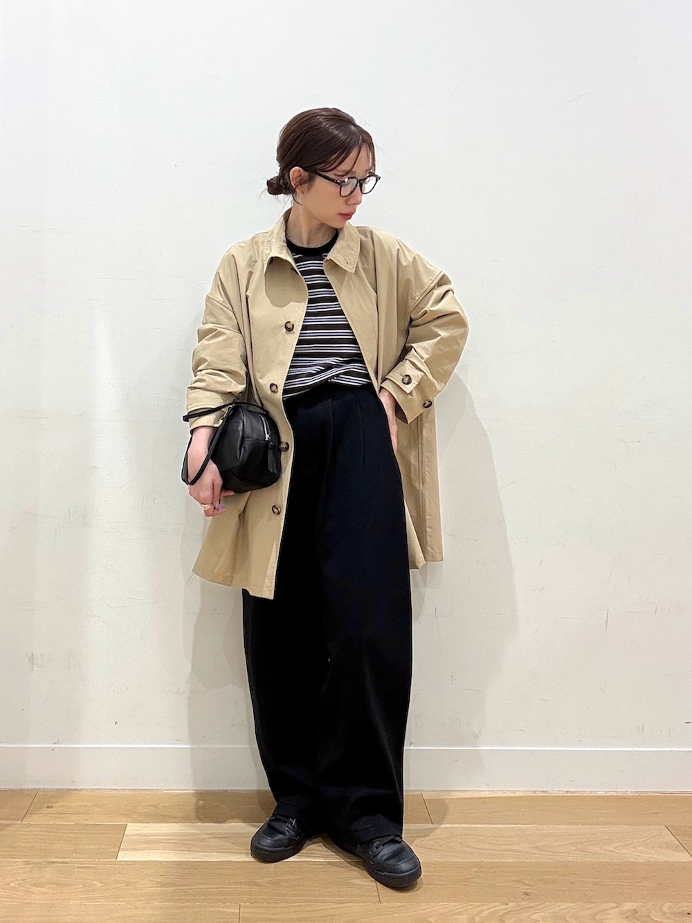 ブラウン系のTシャツ/カットソー、ベージュ系のステンカラーコート、ブラック系のその他パンツを着用したレディースの春コーディネートの4枚目の写真