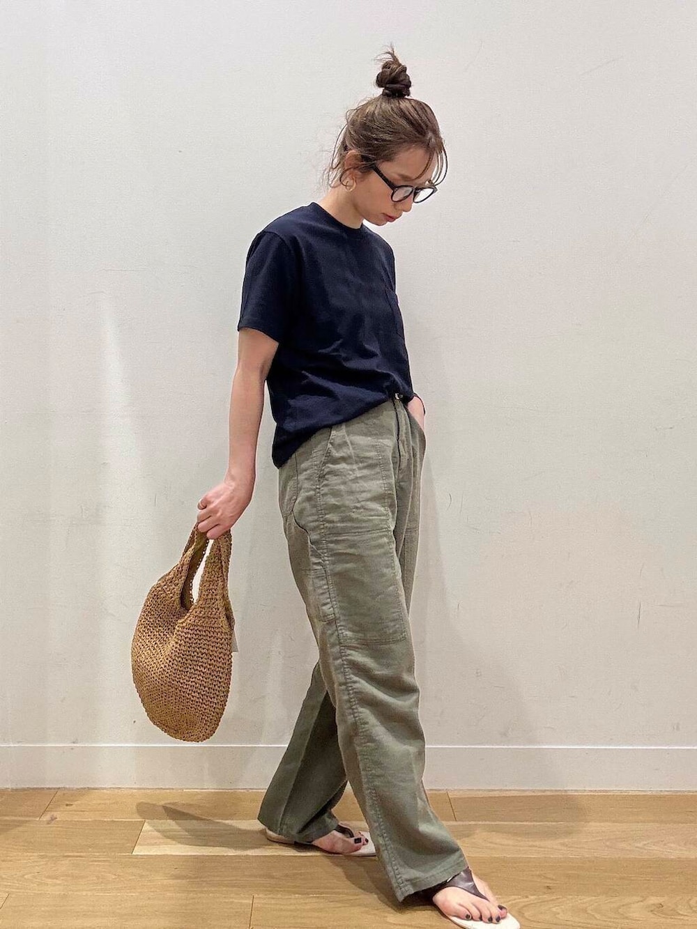 イエロー系のトートバッグ、ブラウン系のサンダル、グリーン系のその他パンツを着用したレディースの春コーディネートの2枚目の写真