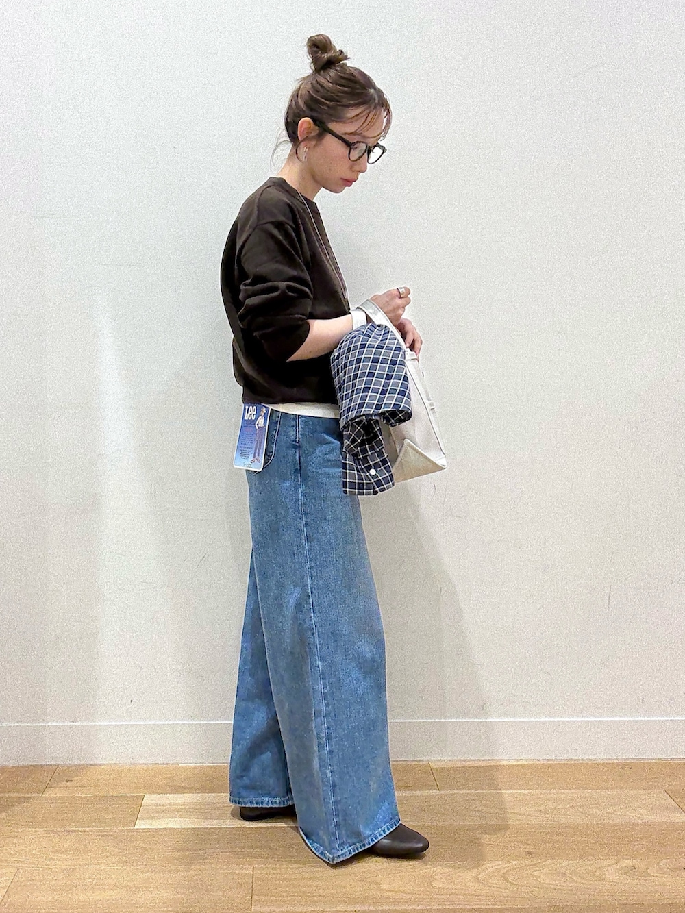 ブラウン系のパンプス、ブラウン系のニット/セーター、ブルー系のシャツ/ブラウスを着用したレディースの秋コーディネートの3枚目の写真