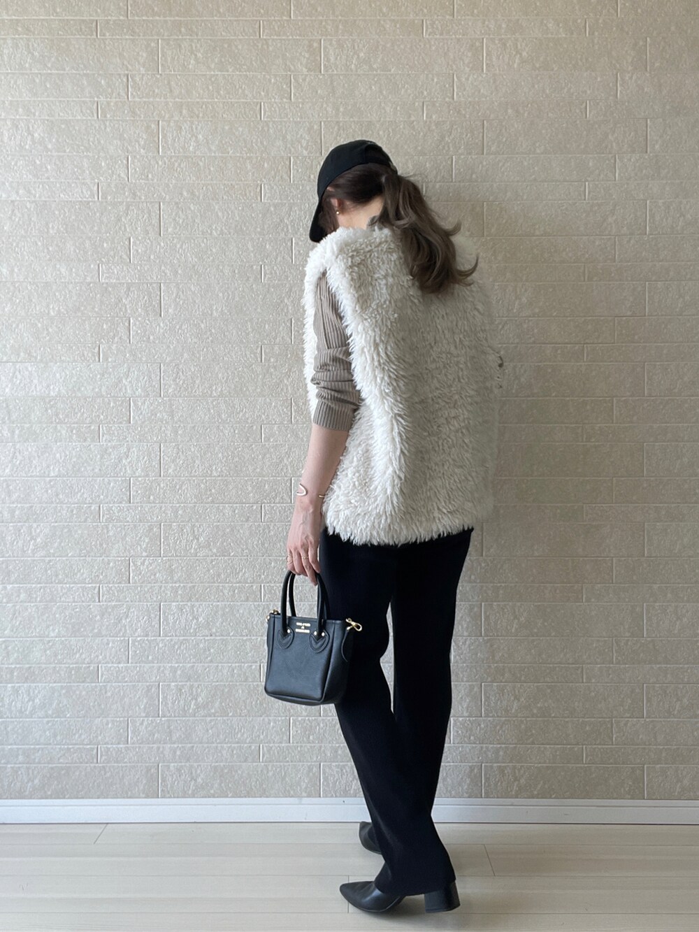 ブラック系のブーツ、ベージュ系のニット/セーター、ブラック系のその他パンツを着用したレディースの秋コーディネートの3枚目の写真