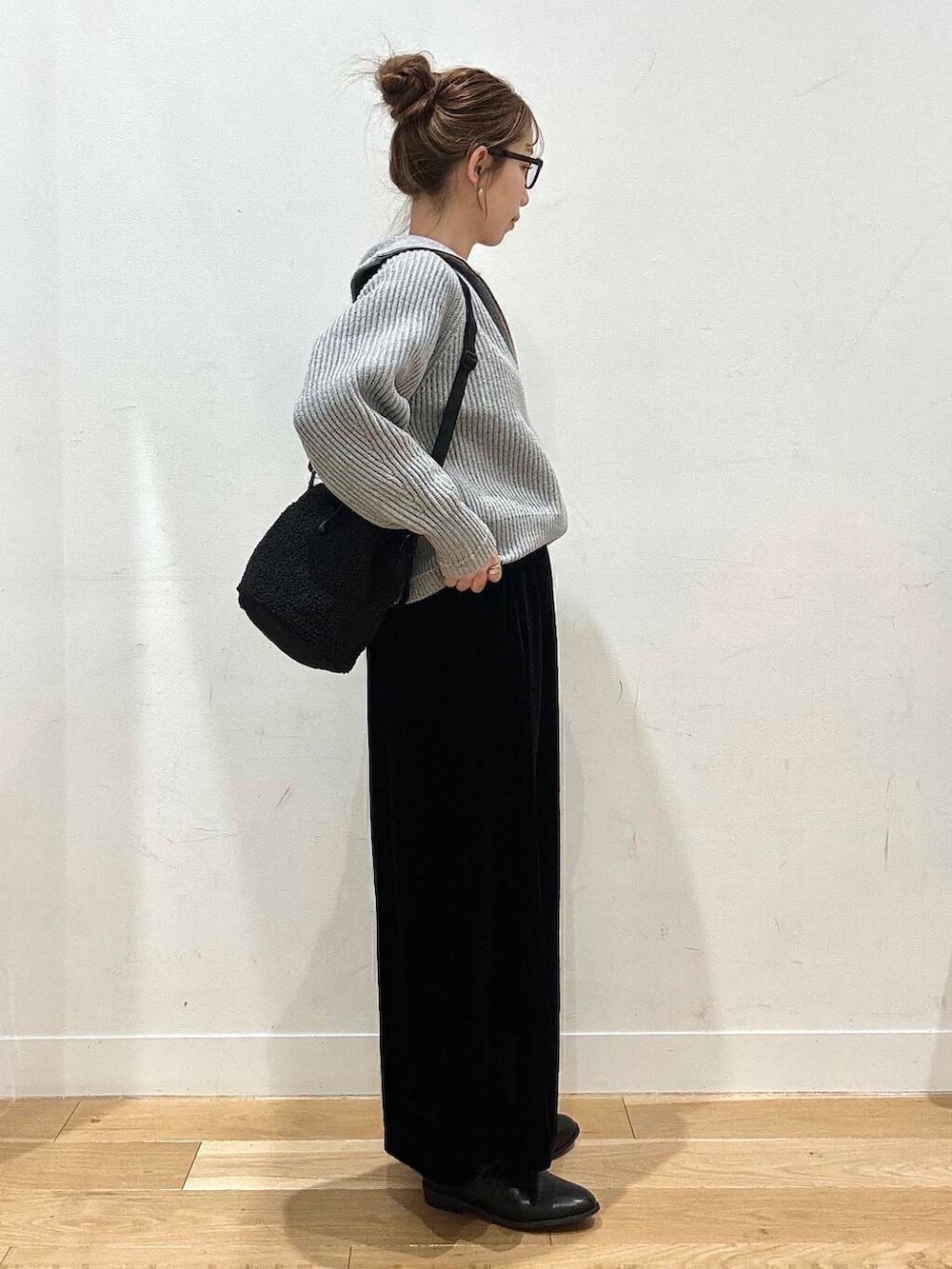 ブラック系のブーツ、グレー系のカーディガン/ボレロ、ブラック系のスカートを着用したレディースの冬コーディネートの6枚目の写真