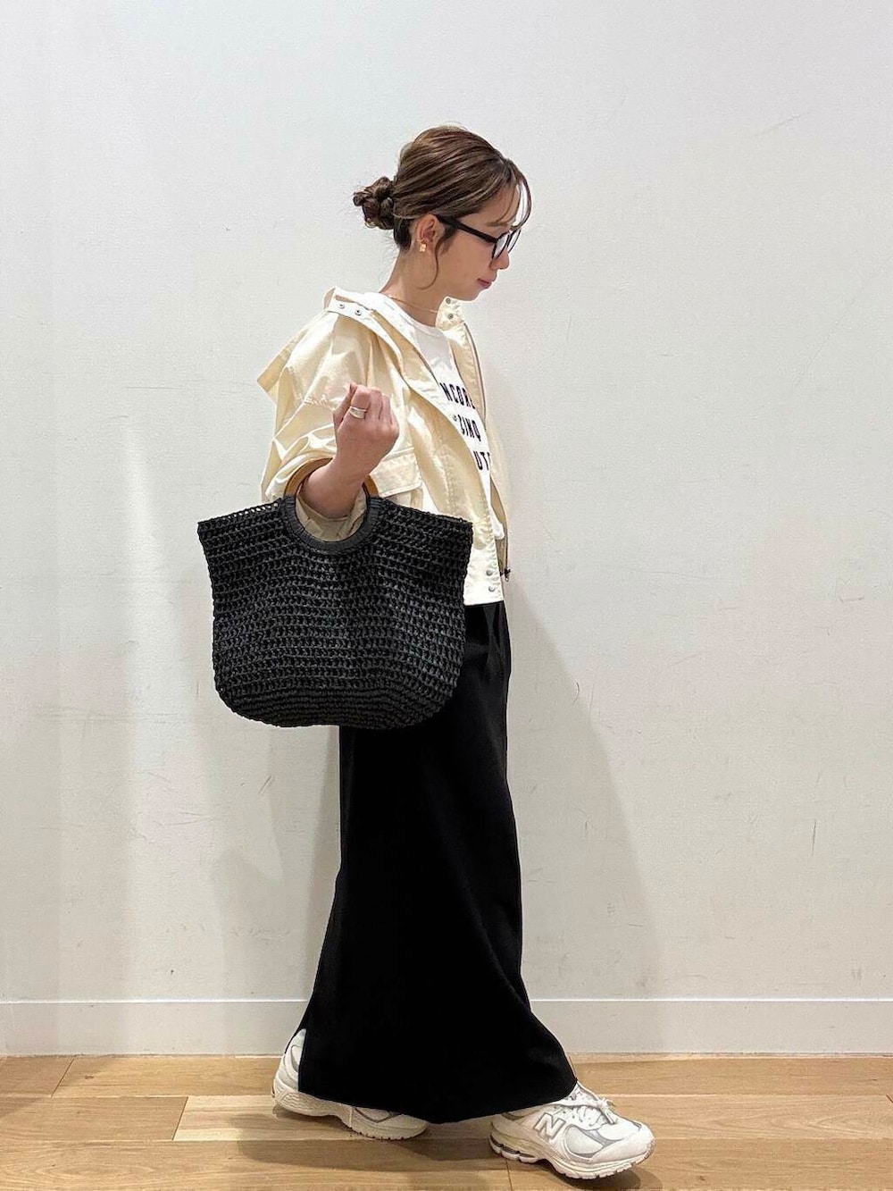 ベージュ系のスニーカー、ホワイト系のマウンテンパーカー、ブラック系のトートバッグを着用したレディースの春コーディネートの2枚目の写真