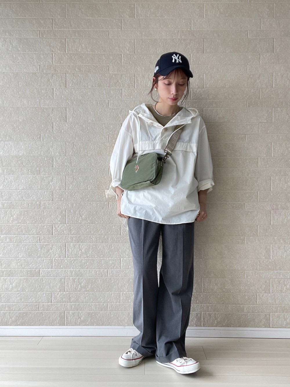 グリーン系のショルダーバッグ、グレー系のその他パンツ、ホワイト系のスニーカーを着用したレディースの春コーディネートの2枚目の写真