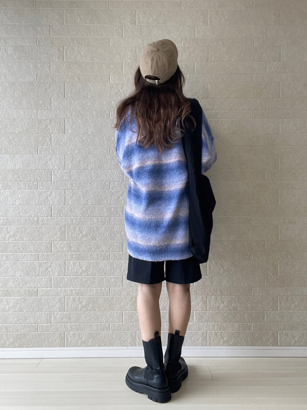 ブルー系のカーディガン/ボレロ、ブラック系のブーツ、ブラック系のその他パンツを着用したレディースの秋コーディネートの3枚目の写真