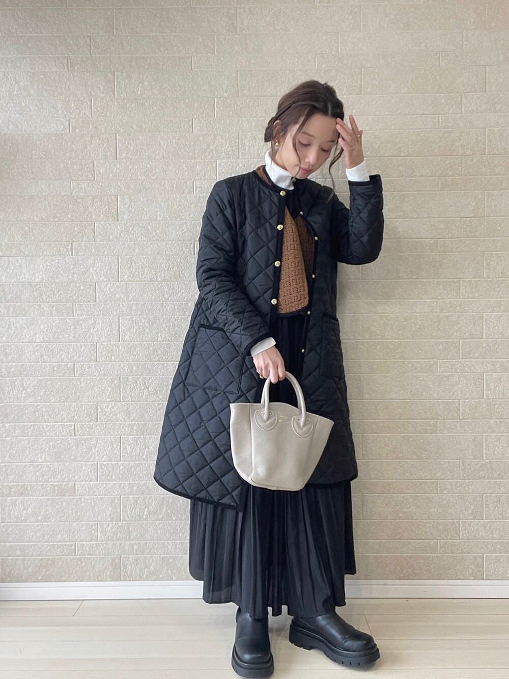 ブラック系のその他アウター、ブラウン系のベスト、ブラック系のブーツを着用したレディースの冬コーディネートの2枚目の写真