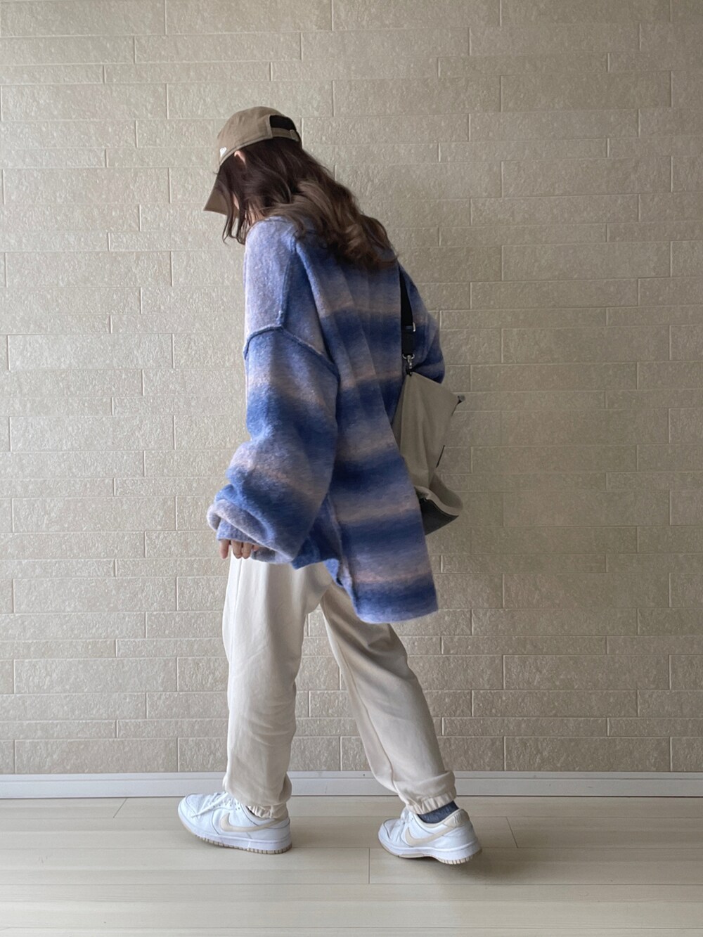 ブルー系のカーディガン/ボレロ、ブラック系のバックパック/リュック、ホワイト系のスウェットパンツを着用したレディースの秋コーディネートの3枚目の写真