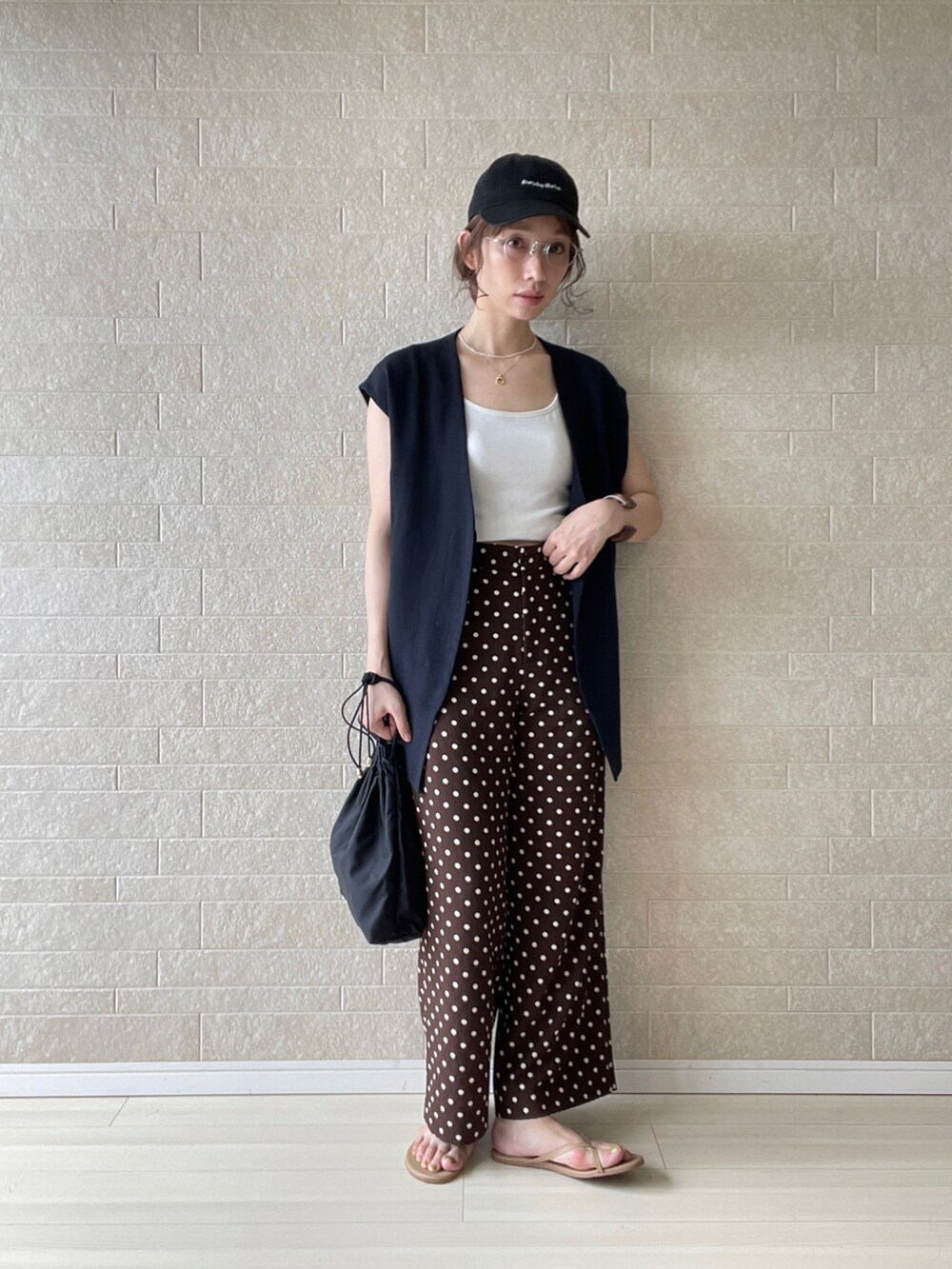 ブラウン系のその他パンツ、ブラック系のベスト、ブラウン系のサンダルを着用したレディースの夏コーディネートの2枚目の写真