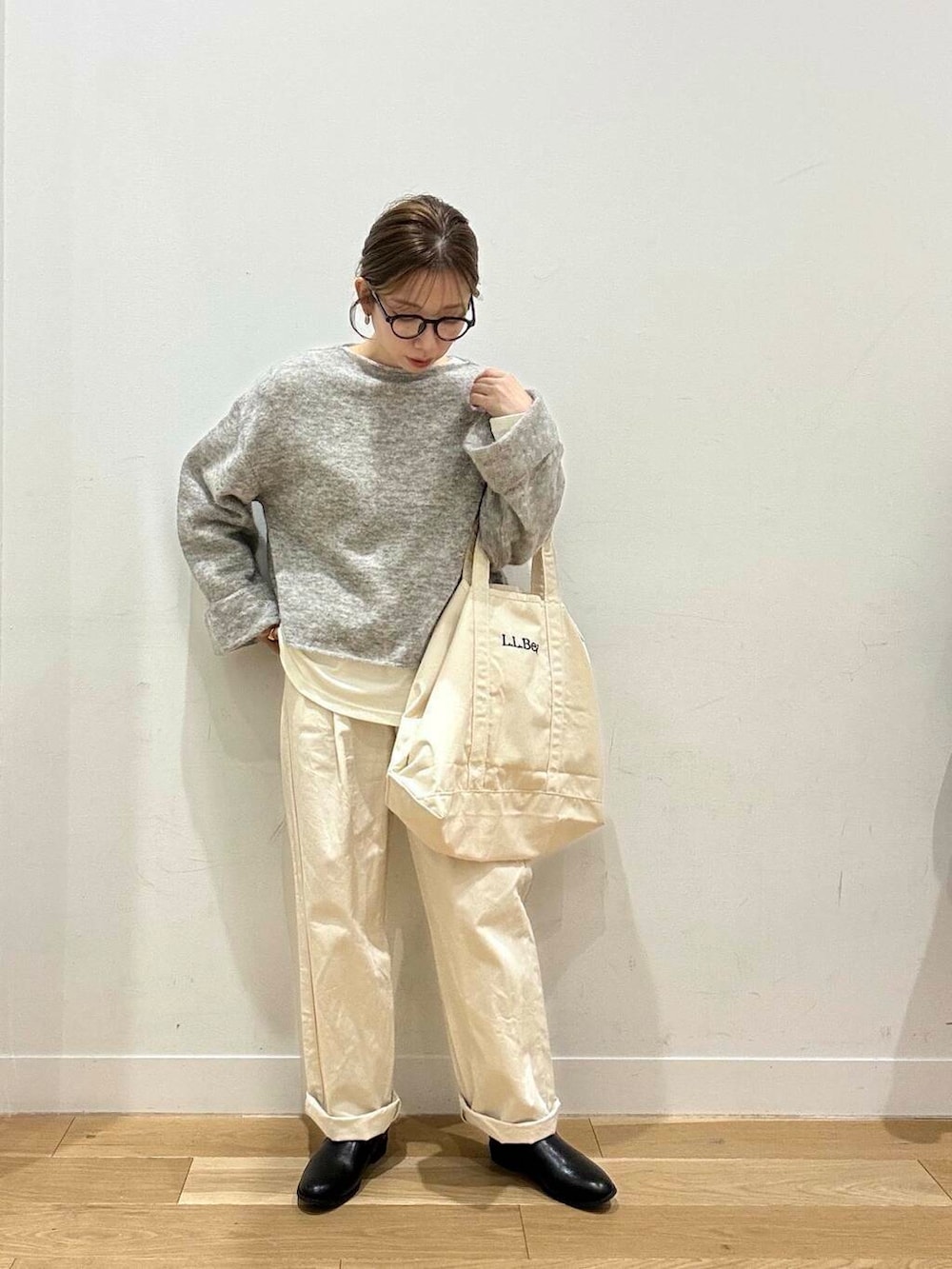 ホワイト系のトートバッグ、ベージュ系のデニムパンツ、ブラック系のブーツを着用したレディースの冬コーディネートの4枚目の写真