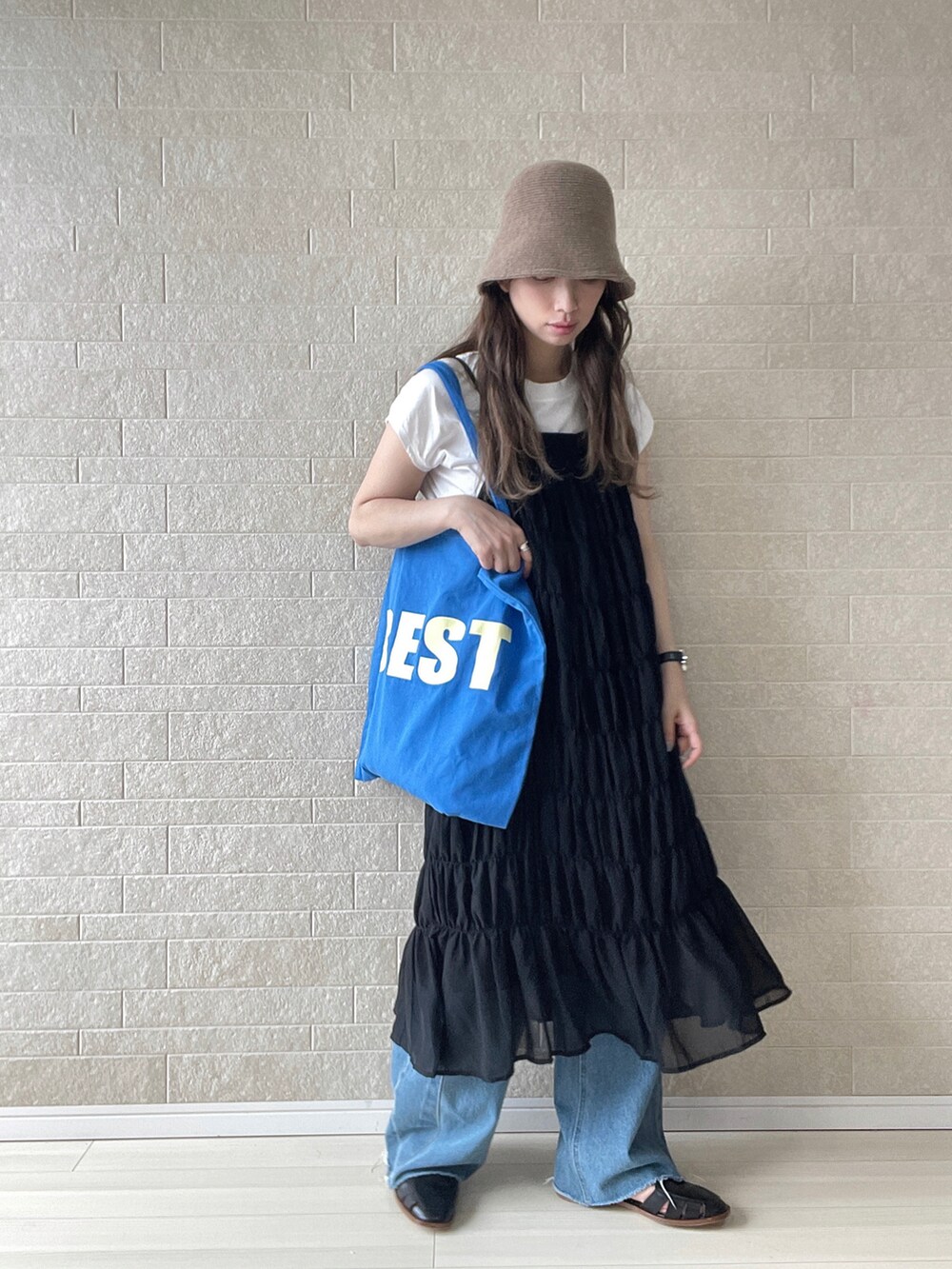 ブラック系のワンピース、ブルー系のトートバッグ、ブルー系のデニムパンツを着用したレディースの夏コーディネートの2枚目の写真
