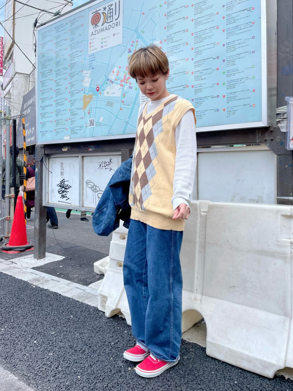 ブルー系のデニムパンツ、レッド系のスニーカーを着用したレディースの春コーディネートの2枚目の写真