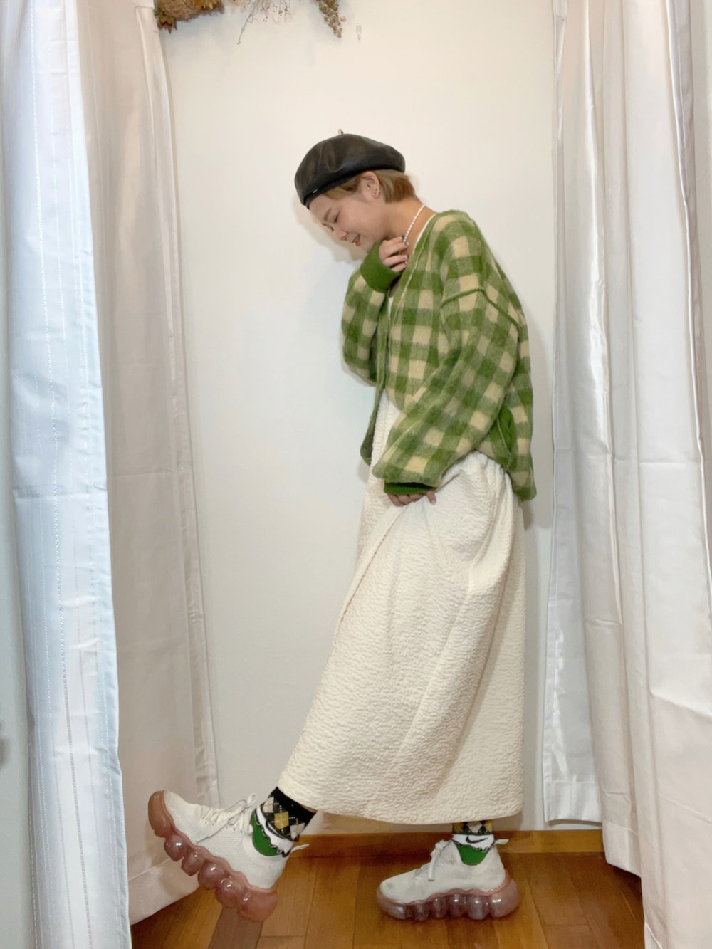 グリーン系のカーディガン/ボレロ、ホワイト系のワンピース、パープル系のスニーカーを着用したレディースの秋コーディネートの2枚目の写真