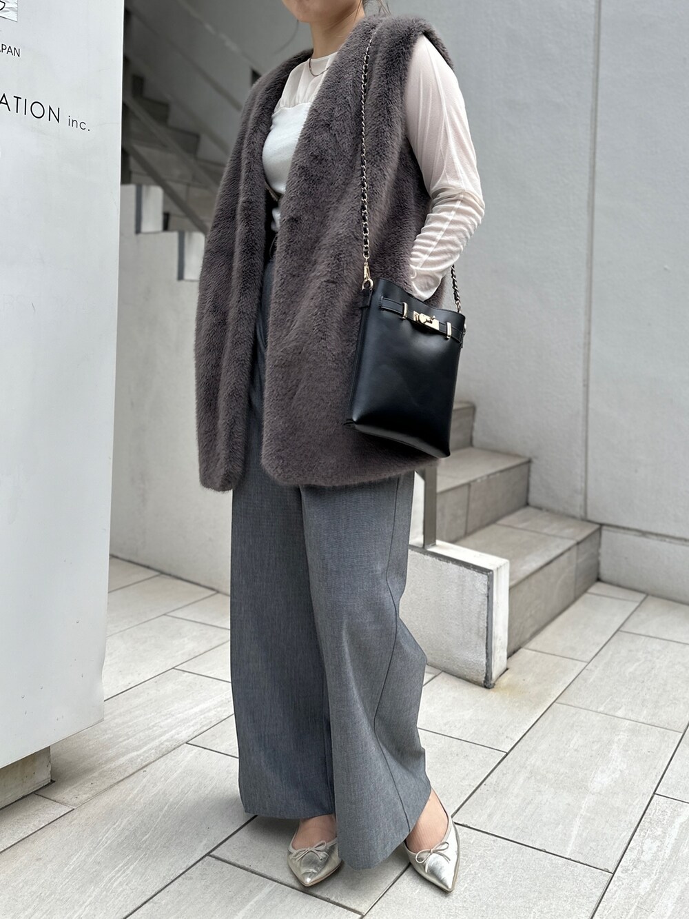 グレー系のベスト、ホワイト系のTシャツ/カットソー、グレー系のその他パンツを着用したレディースの秋コーディネートの3枚目の写真