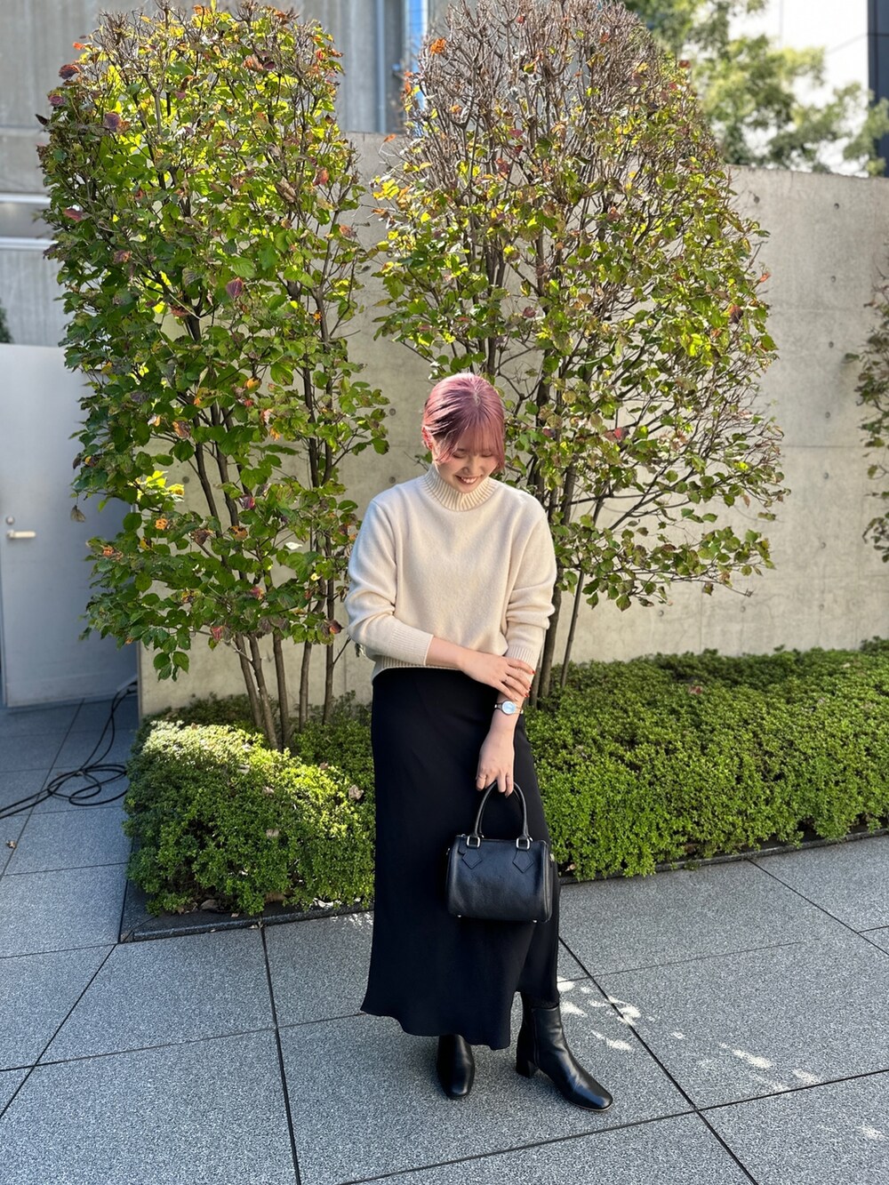 ホワイト系のニット/セーター、ブラック系のスカート、ブラック系のショルダーバッグを着用したレディースの秋コーディネートの3枚目の写真