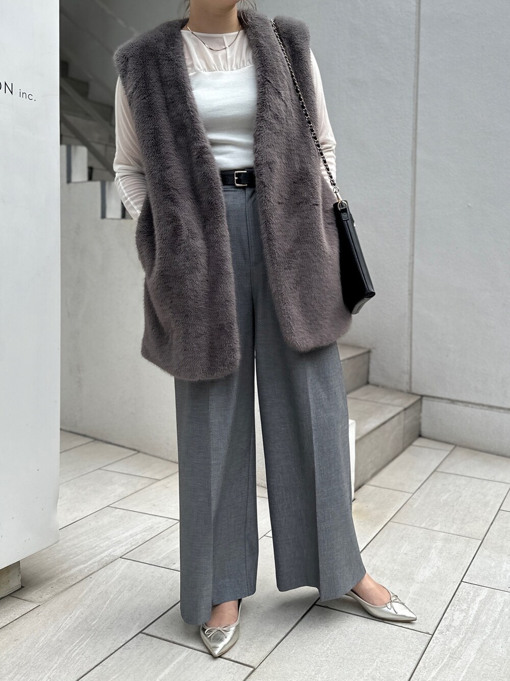 グレー系のベスト、ホワイト系のTシャツ/カットソー、グレー系のその他パンツを着用したレディースの秋コーディネートの4枚目の写真