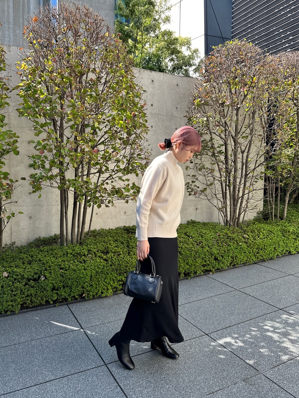 ホワイト系のニット/セーター、ブラック系のスカート、ブラック系のショルダーバッグを着用したレディースの秋コーディネートの2枚目の写真