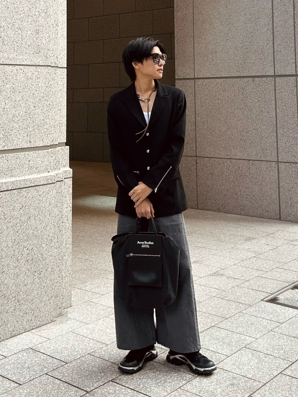 ブラック系のスニーカー、グレー系のデニムパンツ、ブラック系のトートバッグを着用したメンズの秋コーディネートの2枚目の写真